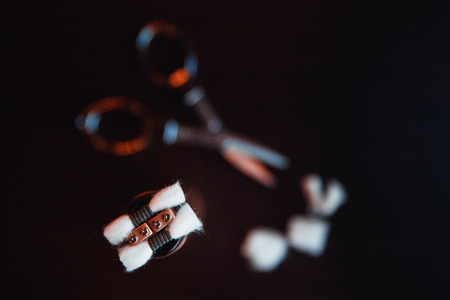 Vape.Scissors, cotton wool and electronic cigarette on a dark wood background. vaping deviceの写真素材