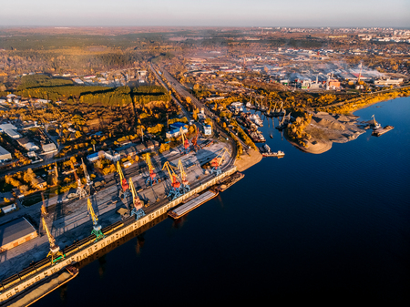 Port river cranes loading ships on barges delivery, sunset. Aerial droneの写真素材