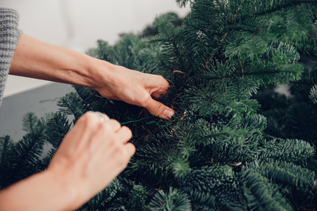 Christmas tree wreath decoration with woman hand workshop DIY.の写真素材