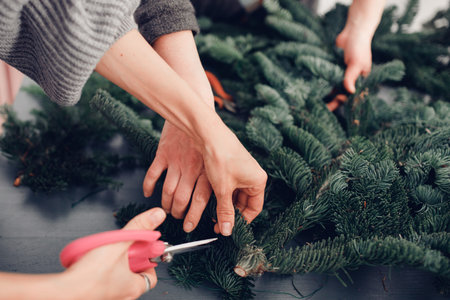 Christmas tree wreath decoration with woman hand workshop DIY.