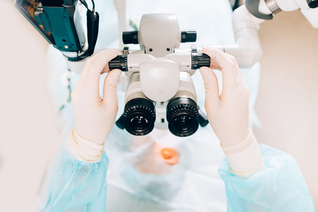 Doctor examines fundus in microscope, patient under sterile cover. Laser vision correction lasik.の写真素材