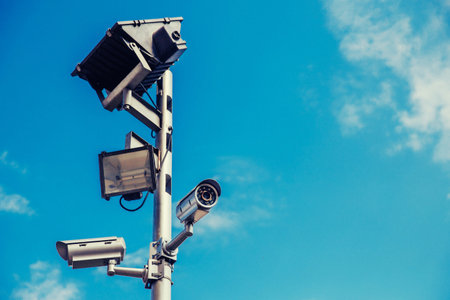 CCTV camera system installed in park, against blue sky. concept of crime control, recognition...