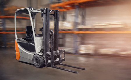 Warehouse industrial premises for storing materials and wood, forklift containers. Concept logistics, transport. Motion blur effect. Bright sunlight.の写真素材