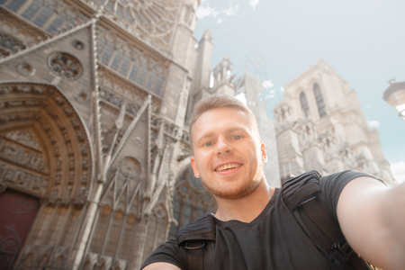 Male traveler makes selfie photo on background of building in France, Paris.の写真素材