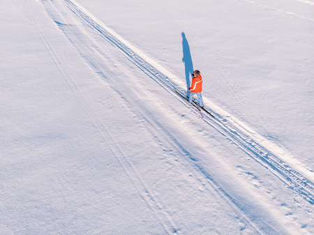 Woman on cross-country skiing rides on snowy track. Leisure concept. Aerial top view.の写真素材