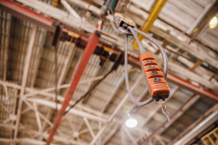 Crane chain and hook blurred warehouse background with remote control. Concept production steel factory.の写真素材
