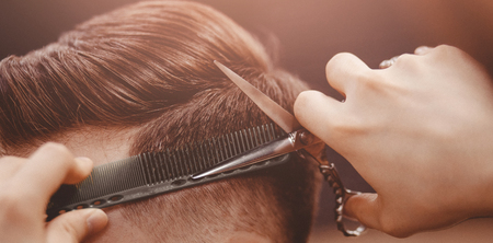 Barbershop banner. Man in barber chair, hairdresser styling his hairの写真素材