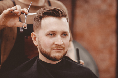 Barbershop banner. Man in barber chair, hairdresser styling his hairの写真素材