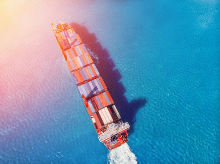 Logistics transportation of International container cargo ship in blue ocean. Top view aerial....