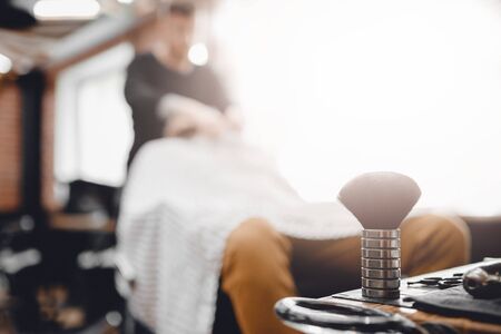 Brush for shaving beard along with bowl, blurred background of hair salon for men, barber shopの写真素材