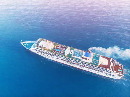 White Cruise ship in blue sea. Aerial top view