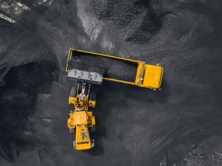 Open pit mine, coal loading in trucks, transportation and logistics, top view aerial drone