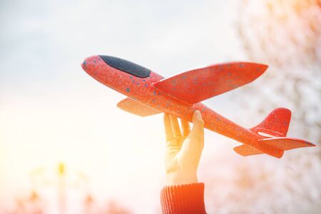 Child holds model aircraft for planning foam, highlight lightの写真素材