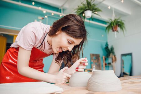 Workplace for manufacture of kraft ceramic tableware, woman works for potter wheelの写真素材