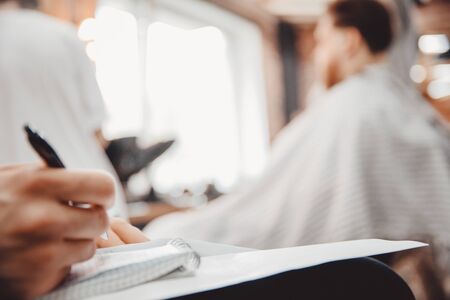 Barber hairdresser training concept. Man outlines with pen on paper how to cutの写真素材