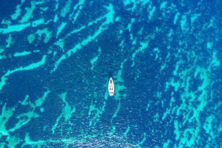 Pleasure white yacht coral reef in blue transparent turquoise water sea. Aerial top view.の写真素材