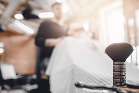 Barbershop, brush for shaving beard along with bowl, blurred background of hair salon for menの写真素材
