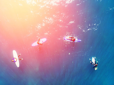 Group of novice surfers are learning to embark on wave. Aerial top view