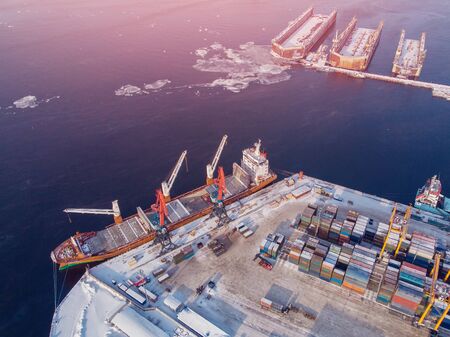 Container cargo ship loading North Arctic port. Concept freight transportation import export and business logistic, aerial view winter.