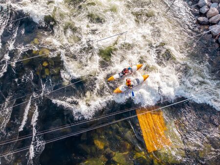 Guy in kayak sails mountain river. Whitewater kayaking, extreme sport rafting. Aerial top viewの写真素材