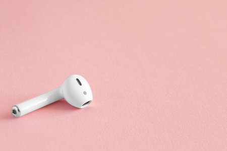 White headphones wireless earphones, copy space pink background.