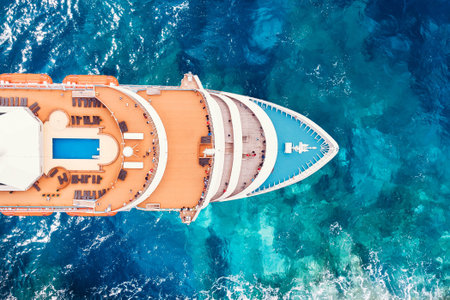 Nose cruise liner ship in ocean with water. Aerial top view