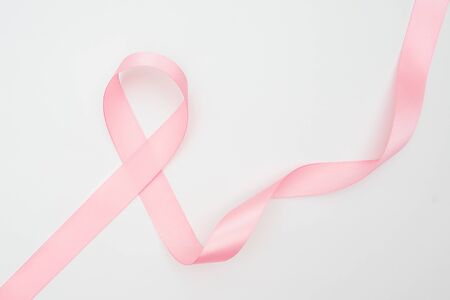 Curled pink ribbon with highlights isolated on white background, top view.の写真素材