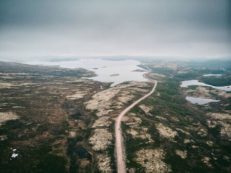 Dramatic scene, road Murmansk region through tundra, direction to Teriberka. Aerial top viewの写真素材