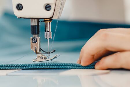 Male hands tailor working on sewing machine, making shopper bag from fabric.の写真素材