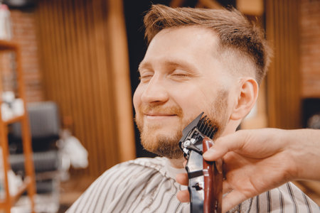 Close-up of barber shaving beard to man in barbershop