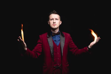 Magician shows trick with fire burn from palms handsの写真素材