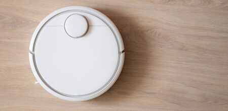 Robotic wireless smart vacuum cleaner working on laminate flooringの写真素材