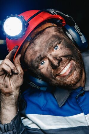 Miner happy man smiling after working on coal mine. Concept industrial engineerの写真素材
