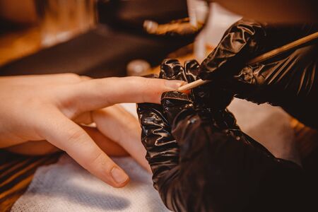 Man makes manicure in beauty salon, master cuts nails.の写真素材