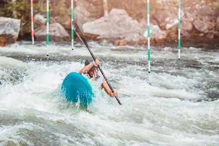 Guy in kayak sails mountain river. Whitewater kayaking, extreme sport rafting.の写真素材