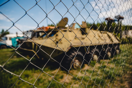 Old soviet russian rusty radioactive equipment stands in dump over fence.