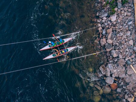 Guy in kayak sails mountain river. Whitewater kayaking, extreme sport rafting. Aerial top view.の写真素材