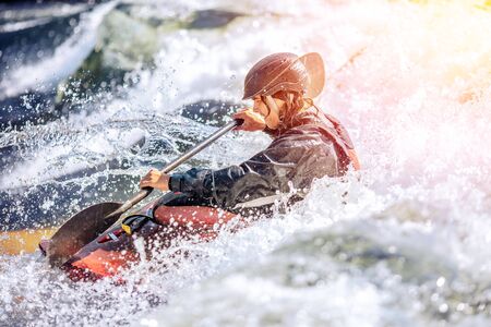 Whitewater kayaking, extreme sport rafting. Guy in kayak sails mountain river.の写真素材