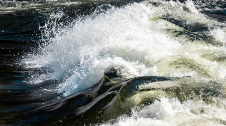 Bursts and rapids of close-up mountain river, waves and splashes.の写真素材