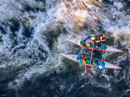 Guy in kayak sails mountain river. Whitewater kayaking, extreme sport rafting. Aerial top view.の写真素材