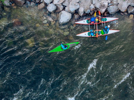 Guy in kayak sails mountain river. Whitewater kayaking, extreme sport rafting. Aerial top view.