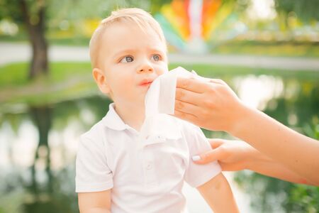 Mom wipes napkins baby face ice cream clearの写真素材