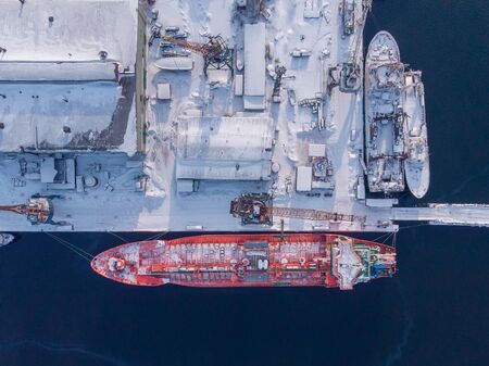 Commercial north arctic port is loading containers onto cargo tanker ship. Concept logistics and delivery of goodsの写真素材