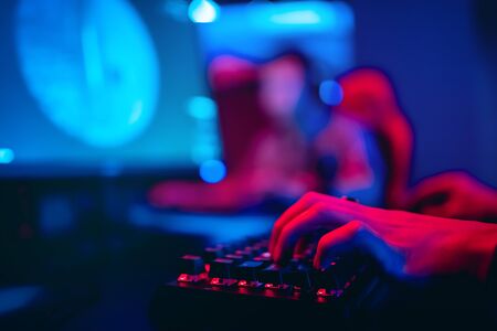 Blurred background computer, keyboard, blue and red lights. Concept eSports arena for gamer playing tournaments.の写真素材