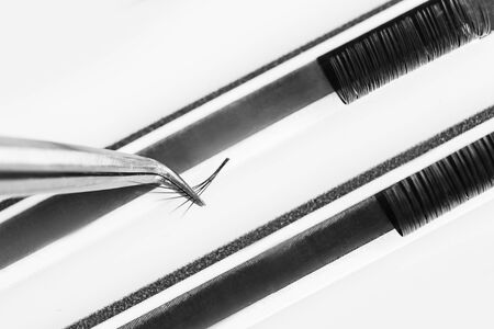 Eyelash extension procedure. Lashes tweezers set macro photo, isolated white background.の写真素材