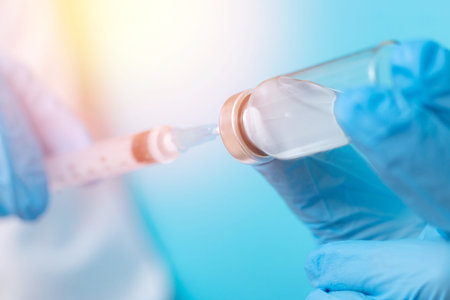 Doctor hand holding syringe and vaccine in blue gloves white coat, sun light. Concept disease...