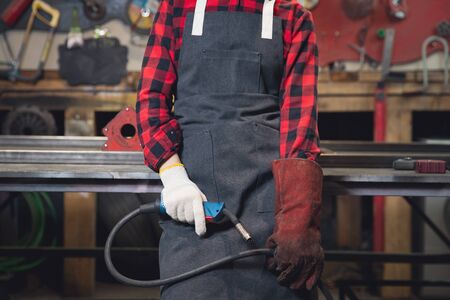 Worker with welding on steel structure in factory, light sparkの写真素材