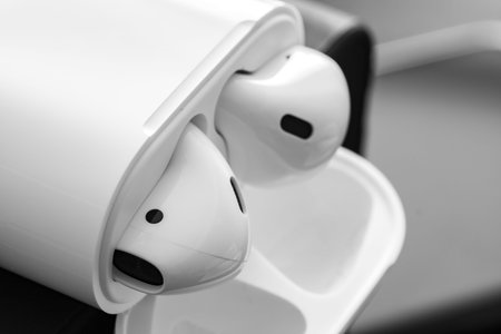 Case for white headphones storage and charging, wireless earphones, black background