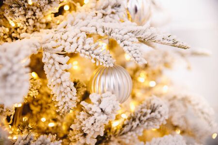Christmas white tree decorated snow illumination and gifts toys, background light bokehの写真素材