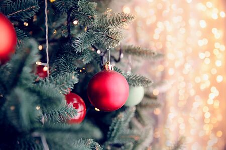 Christmas background tree New Yeae branch with decorations red balls gifts and star, with bokeh light. Copy spaceの写真素材